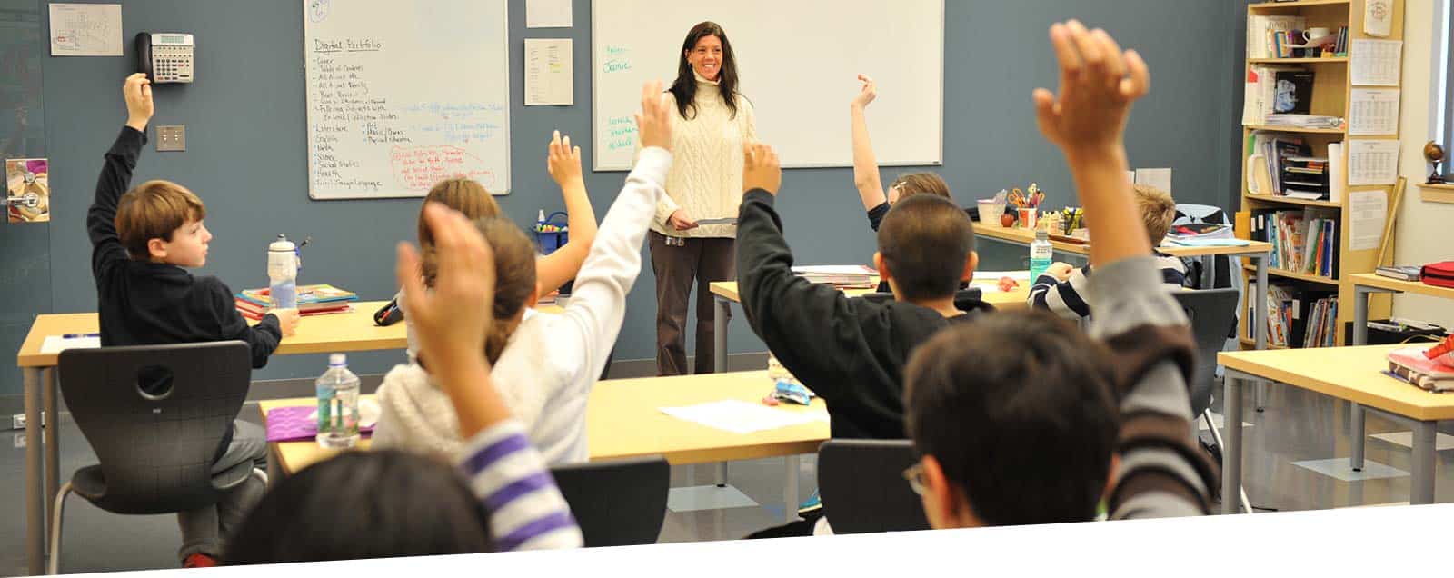 Kids raising their hands in classroom