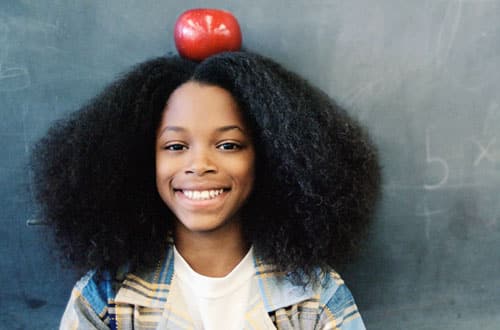 Girl smiling with apple on her head