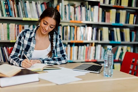 Woman writing in library