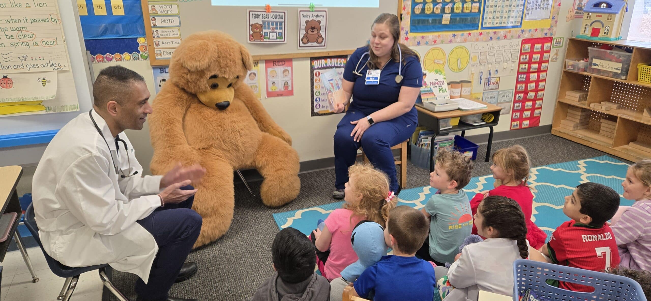 Kindergarten class enjoying a story with visiting nurse and doctor